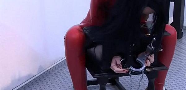  Girl in red latex tied up tries to get out
